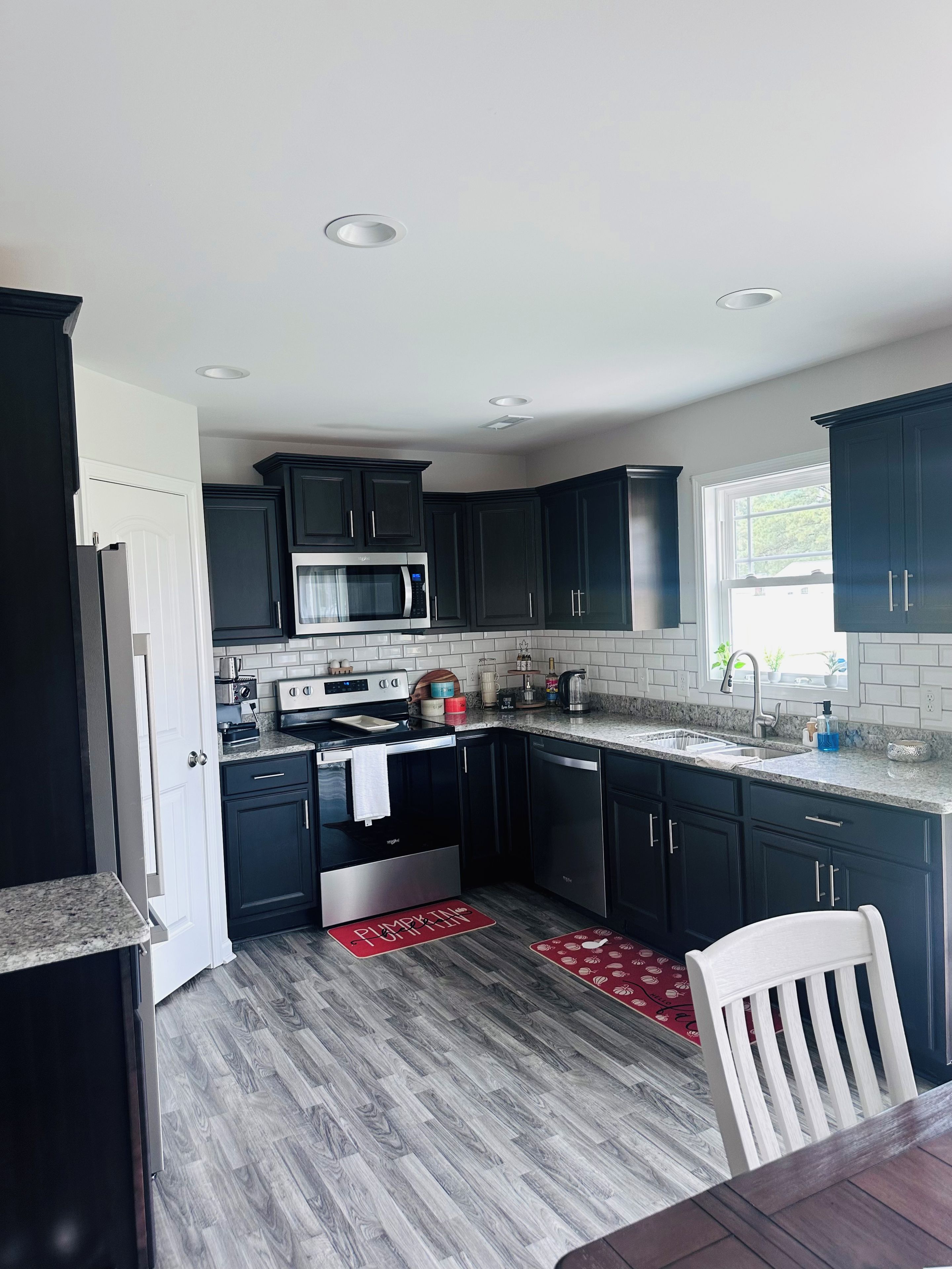 A modern kitchen with dark cabinets, a stainless steel range, and a granite countertop.