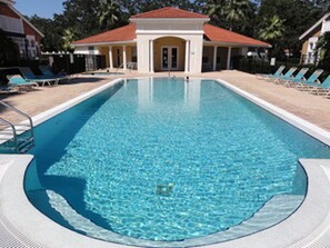 Ein rechteckiger Pool mit einer gefliesten Sonnenterrasse rundherum.