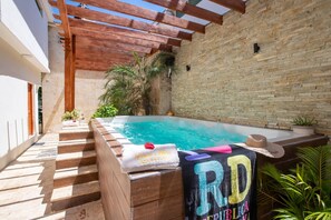 A hot tub with a towel and a sign, surrounded by a wooden deck and a brick wall. - Room-getaway Room With Shared Jacuzzi in (Sosúa)