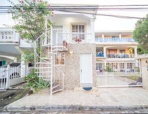 A two-story building with a spiral staircase, a gated entrance, and a balcony. - Studio in Sosua Center! Near Sosua Beach (Sosúa)