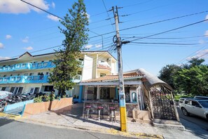 A building with a bar area, outdoor seating, and a covered entrance. - Cheap Hotel Room in Sosua Strip! (Sosúa)