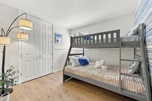A bunk bed with a ladder, a bedside table, a lamp, a potted plant, and a door with a mirror. - Single-Story 4BR · King Suite · Treehouse & Deck (Pleasanton)