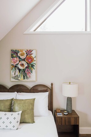 A bedroom with a bed, pillows, a nightstand with a lamp, a painting, and a skylight. - Lookout MTN Escape - Hot Tub - Fire Pit - Arcade (Golden)