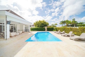 A swimming pool with lounge chairs, a covered patio area, and a view of the sky. - Luxury 2BR Villa in Ocean Village by Santa Fe (Sosúa)