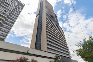 Un bâtiment moderne et imposant, caractérisé par une structure verticale marquée et une série de fenêtres horizontales.