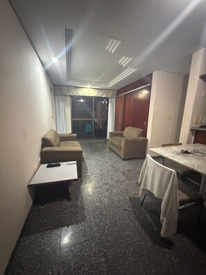 A compact living space with a sofa, a small table, and a dining area. - Apartment on the beachfront in Fortaleza (Fortaleza)