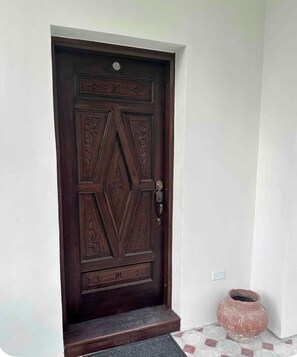 A dark wooden door with intricate carvings and a metal handle. - Organic Modern Retreat in San Juan with Private Patio (San Juan)