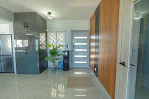 A modern kitchen with stainless steel appliances, a potted plant, and a water dispenser.