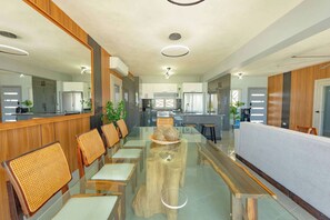 A modern kitchen with stainless steel appliances, a central island with seating, and wooden accents.
