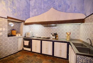 A kitchen with patterned tiles, a gas stove, a sink, and a wooden ceiling. - Gorgeous house for rent in Cartagena, Colombia (Cartagena de Indias)