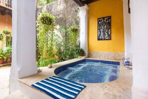 A hot tub area with a tiled edge, a blue and white striped mat, and a wall-mounted artwork. - Gorgeous house for rent in Cartagena, Colombia (Cartagena de Indias)