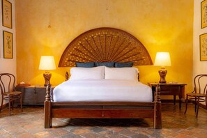 A bed with a wooden headboard, two bedside tables with lamps, and a nightstand with a lamp. - Gorgeous house for rent in Cartagena, Colombia (Cartagena de Indias)