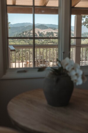 A view from a window with a balcony, overlooking a landscape with hills and trees. - Sunstone Cottage the Bordeaux Suite (Santa Barbara County)