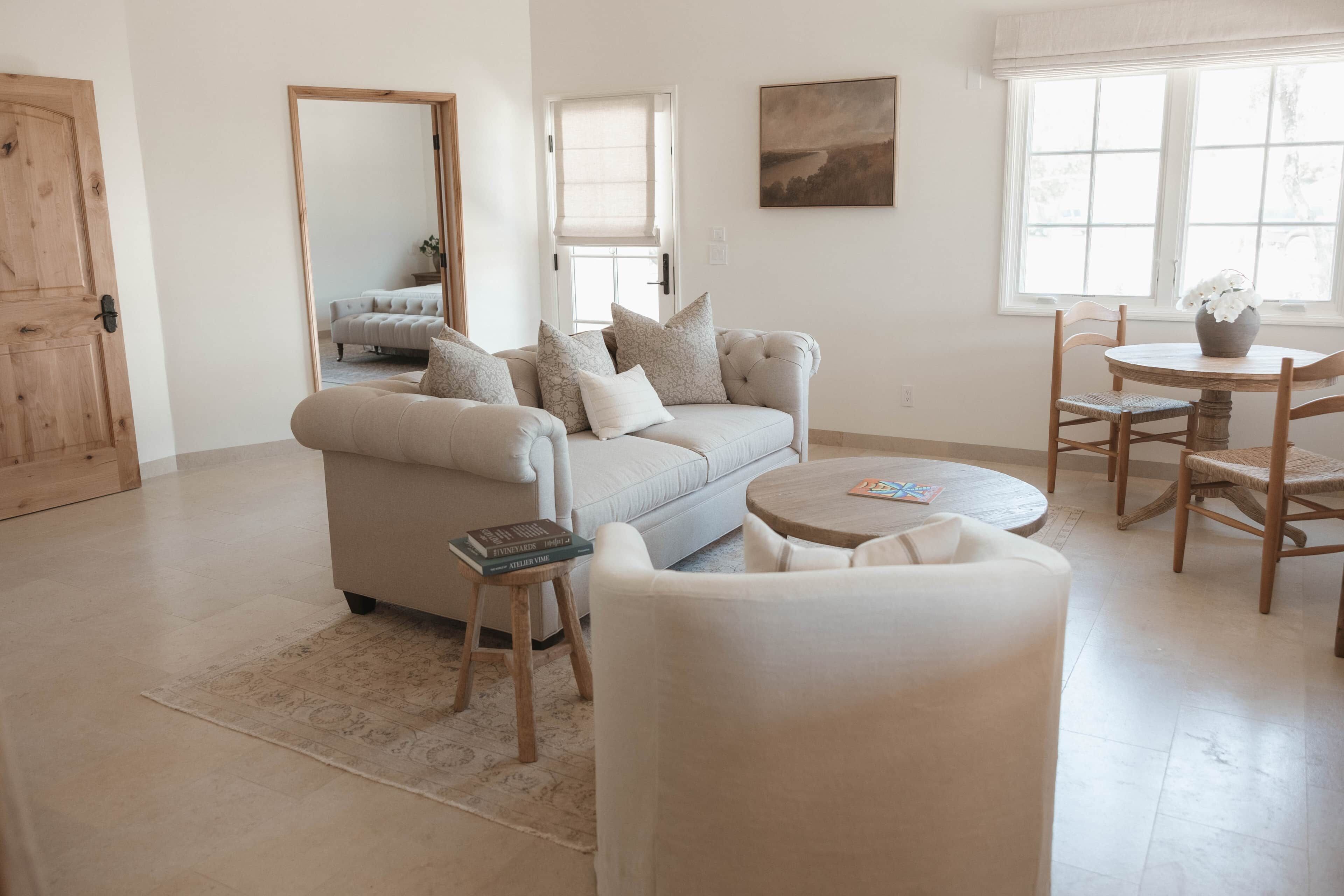 Una sala de estar con sofá, sillones, una mesa de centro y una mesa de comedor con sillas.
