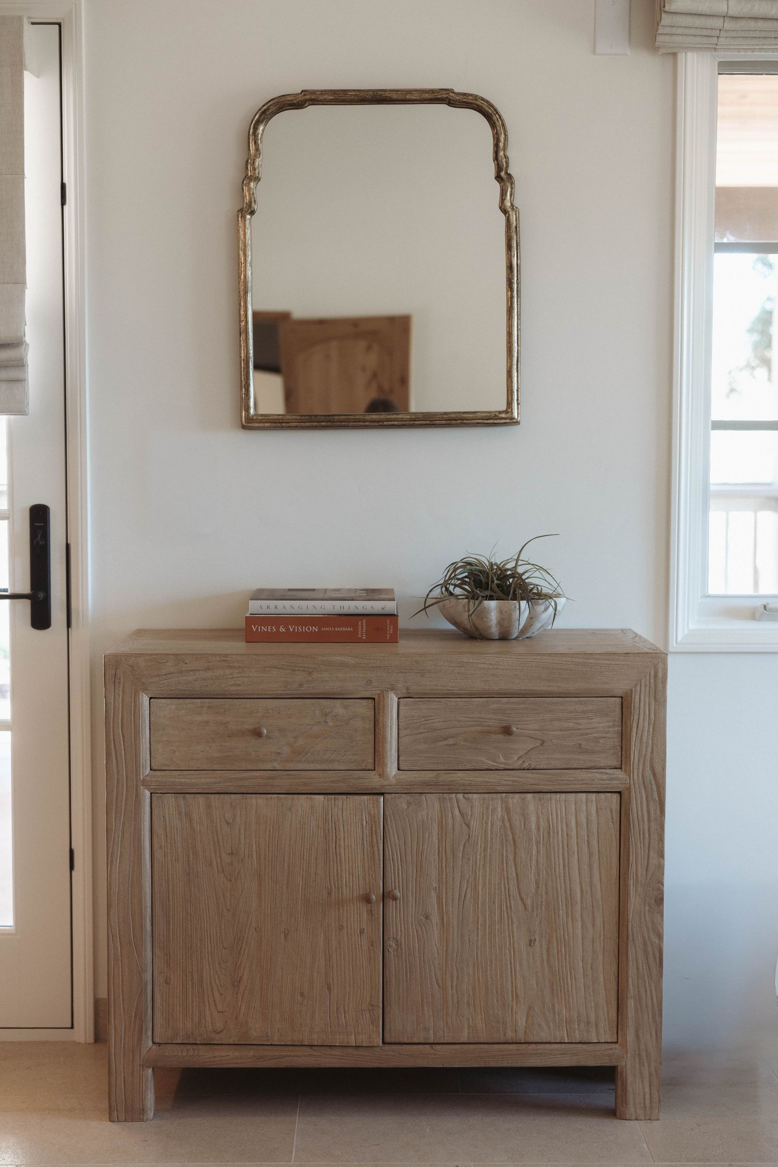 Un mueble de madera con dos cajones y un espejo encima.