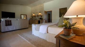 A bedroom with a bed, a bedside table with a lamp, a plant, and a book.