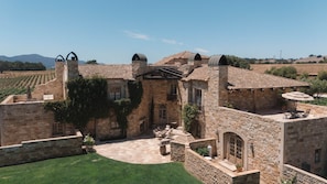A stone building with a courtyard, outdoor seating, and a view of the surrounding landscape.
