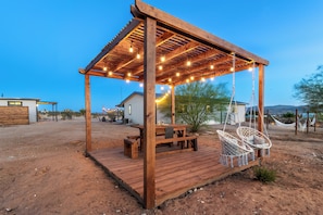 A wooden pergola with string lights, a picnic table, and a hammock. - Beyond Horizon, Private Casita, Stargazing & Fast WiFi (Joshua Tree)