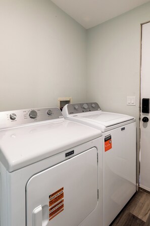 A laundry room with two Maytag dryers, a door, and a light switch on the wall. - Beyond Horizon, Private Casita, Stargazing & Fast WiFi (Joshua Tree)