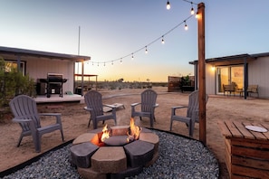 A patio area with a fire pit, outdoor seating, and string lights. - Beyond Horizon, Private Casita, Stargazing & Fast WiFi (Joshua Tree)