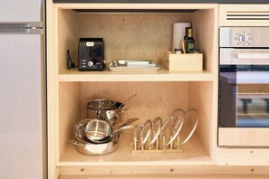 A kitchen with a toaster, a bottle of olive oil, and stainless steel cookware on shelves. - Scandi Spruce Cabin in the Woods #2 (Grand Rapids)