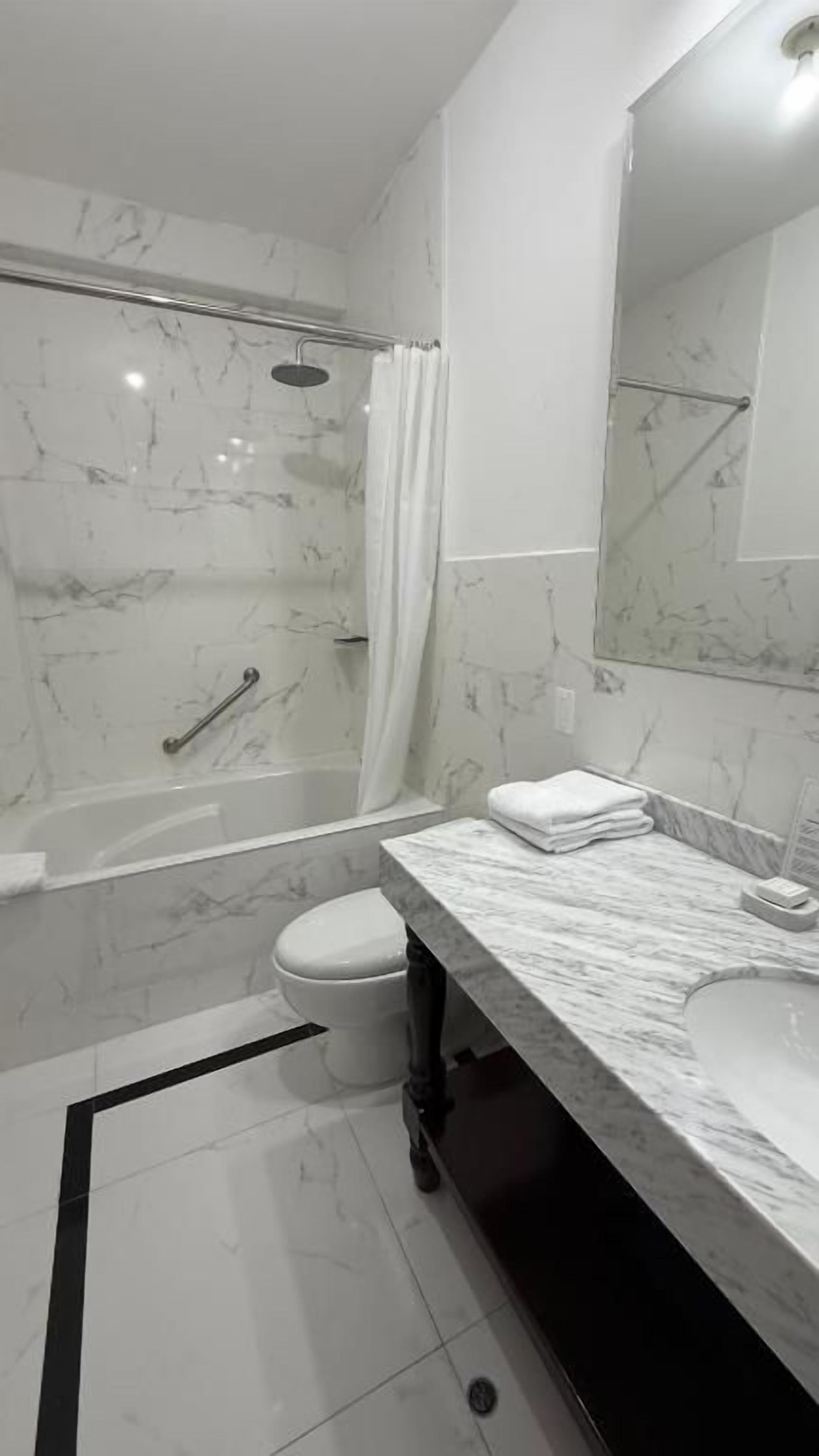 Ein Badezimmer mit Dusche, Toilette und Waschbecken.
