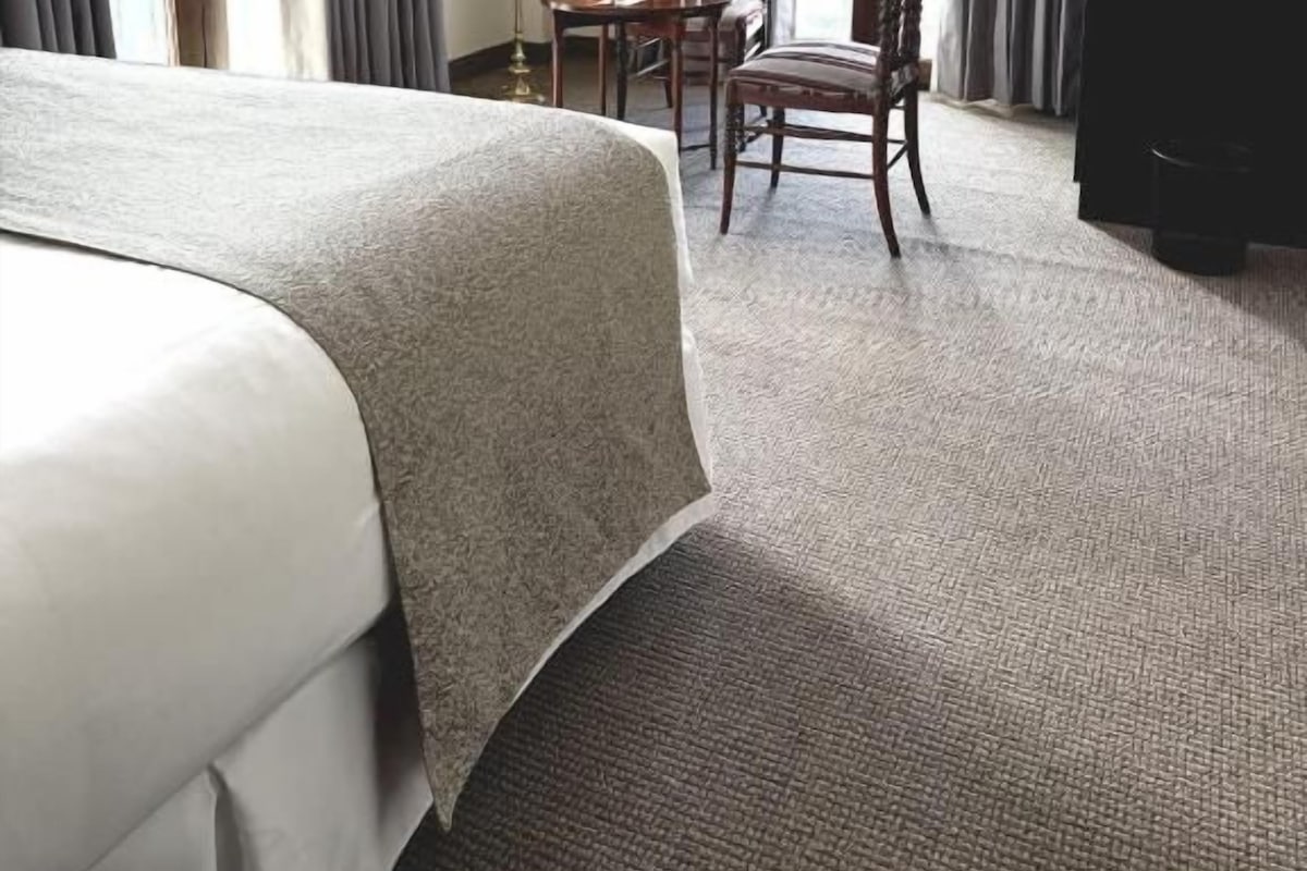 Quarto de hotel com cama grande, escrivaninha, cadeira e televisão.