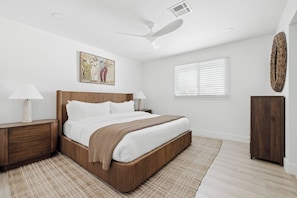 A bedroom with a bed, nightstands, a ceiling fan, a window with blinds, and a wall-mounted artwork. - Terra Aura: Tempe Home with Pool & Spa (Tempe)