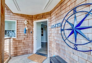 A wooden exterior wall with a compass decoration and a door leading to an interior space. - Sea La Vie- Luxury Ocean View Condo- 1 to 6 month stay (Seaview)