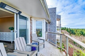 A balcony with two chairs, a table, and a potted plant. - Sea La Vie- Luxury Ocean View Condo- 1 to 6 month stay (Seaview)
