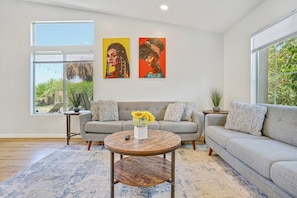 A living room with a sofa, coffee table, and artwork on the wall. - Pool, Spa & Games  4BR Near Indio Polo Grounds (Indio)