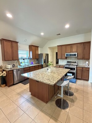 A modern kitchen with granite countertops, stainless steel appliances, and wooden cabinets. - Spacious, bright & modern 3BR+ office in a very safe neighborhood with lakes. (Houston)
