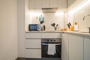 A compact kitchen with a built-in oven, a microwave, and a sink. - Study with a large window · Featured Design (H13) (Providencia)