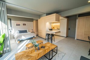 A modern hotel room with a bed, a dining area, and a kitchenette. - Study with a large window · Featured Design (H13) (Providencia)