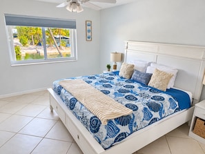 A bedroom with a bed, a window, a ceiling fan, and a nightstand. - Marathon Key Getaway (Marathon)