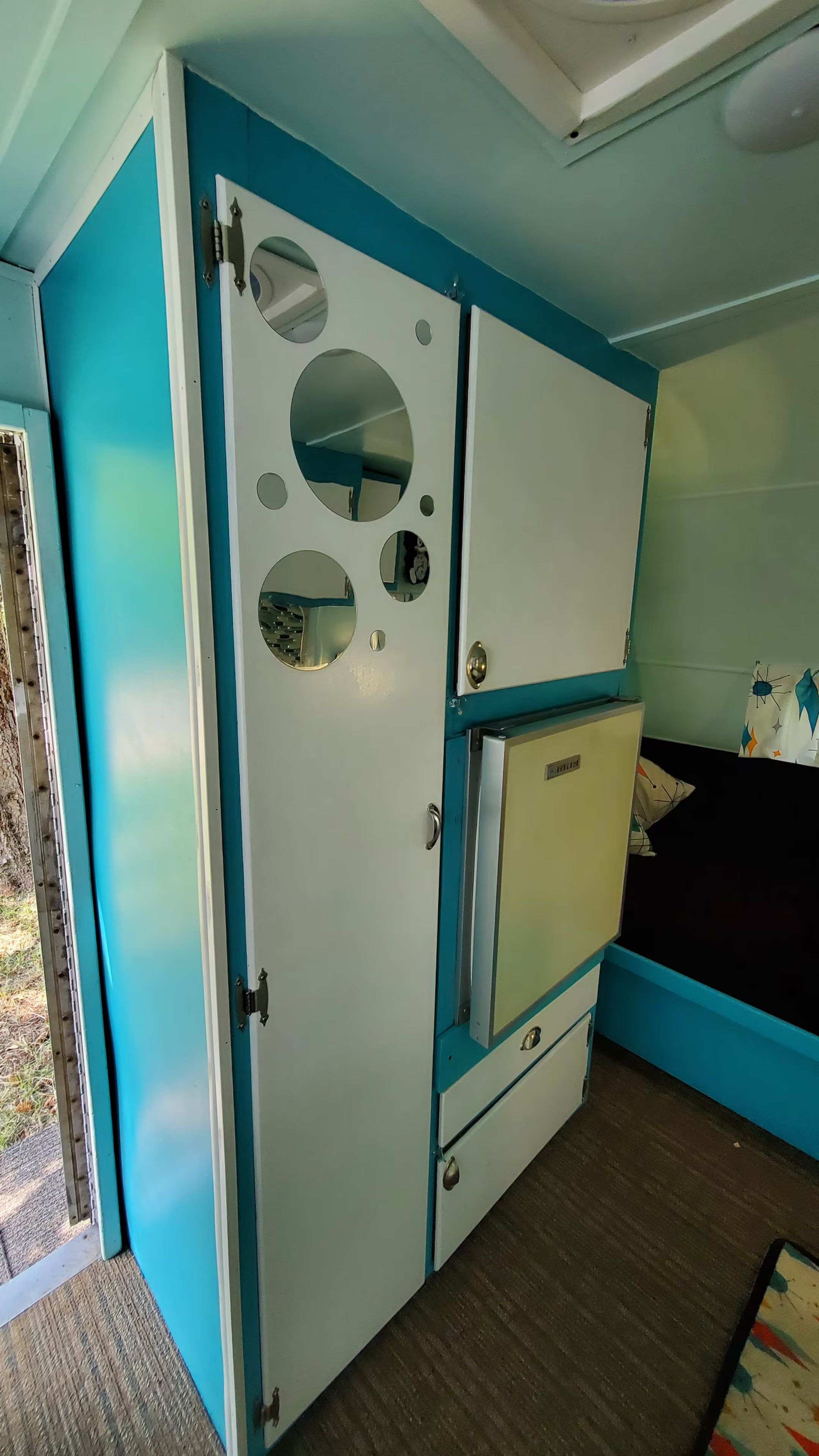 A room with a bed, a wardrobe, and a small cabinet.