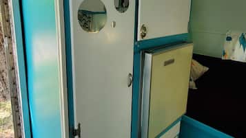A room with a bed, a wardrobe, and a small cabinet.