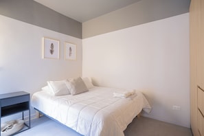 A bedroom with a bed, a bedside table, and two framed pictures on the wall. - Bright 1-room apartment + large window · Featured (H16)   (Providencia)