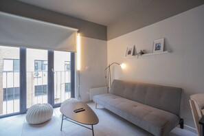 A modern living room with a sofa, a coffee table, and a floor lamp. - Bright 1-bedroom apartment + large window · Selected (H16) (Providencia)
