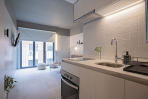 A modern kitchen with a built-in oven, a sink, and a dining area with a bench. - Bright 1-bedroom apartment + large window · Selected (H16) (Providencia)
