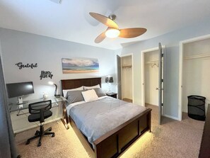 A bedroom with a bed, a desk, a chair, a ceiling fan, and a wall with motivational quotes. - Modern 4BR Retreat Extended Stay Ideal. SW Houston (Sugar Land)