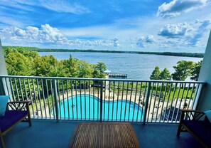 A balcony with a view of a lake, a swimming pool, and a dock. - Balcony Lake Views | Pool, Gym, WiFi & Parking (Orlando)