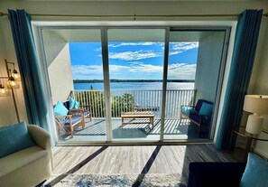 A balcony with a view of a lake and a distant tree line. - Balcony Lake Views | Pool, Gym, WiFi & Parking (Orlando)