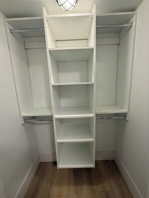 A white closet with three shelves and a hanging rod. - Spacious 2BR Suite| Walk to White Rock Beach (White Rock)
