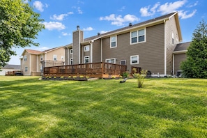 A two-story residential building with a fenced backyard, a wooden deck, and a well-maintained lawn. - The Westfield Retreat | 7 Bedrooms • 30+ Day Stays (Westfield)