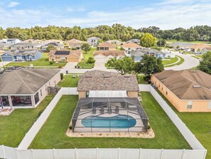 A residential area with houses, a swimming pool, and a covered patio area. - 3BR Lakeland Getaway | Pool & AC Game Room (Lakeland)