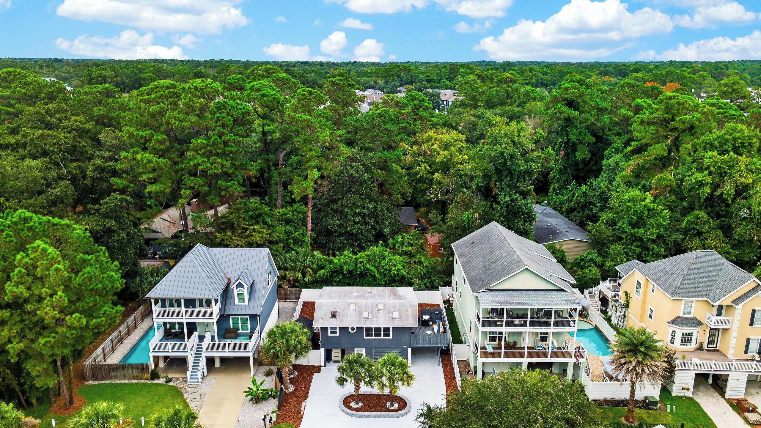 A residential area with multiple houses surrounded by dense greenery.