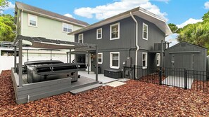 A two-story house with a covered outdoor grill area and a fenced yard. - Bradley Beach House by Avantstay Walk to the Beach Hot Tub + Game Room & BBQ Deck (Hilton Head Island)