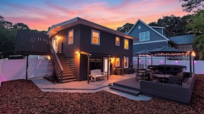 A two-story house with a covered patio area and a deck. - Bradley Beach House by Avantstay Walk to the Beach Hot Tub + Game Room & BBQ Deck (Hilton Head Island)