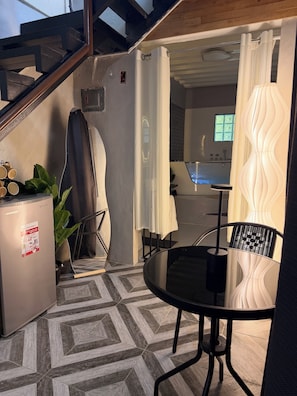 Una cucina moderna con lavastoviglie integrata, un'area pranzo con tavolo e sedie rotonde, e una scala che conduce a un piano superiore.